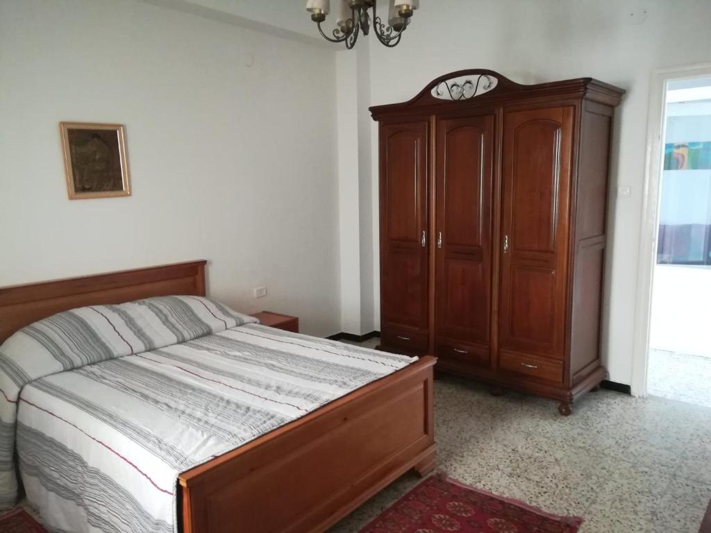 1 dormitorio con 1 cama y armario de madera en L'espadon de Mahdia Maison avec petit jardin en Mahdia
