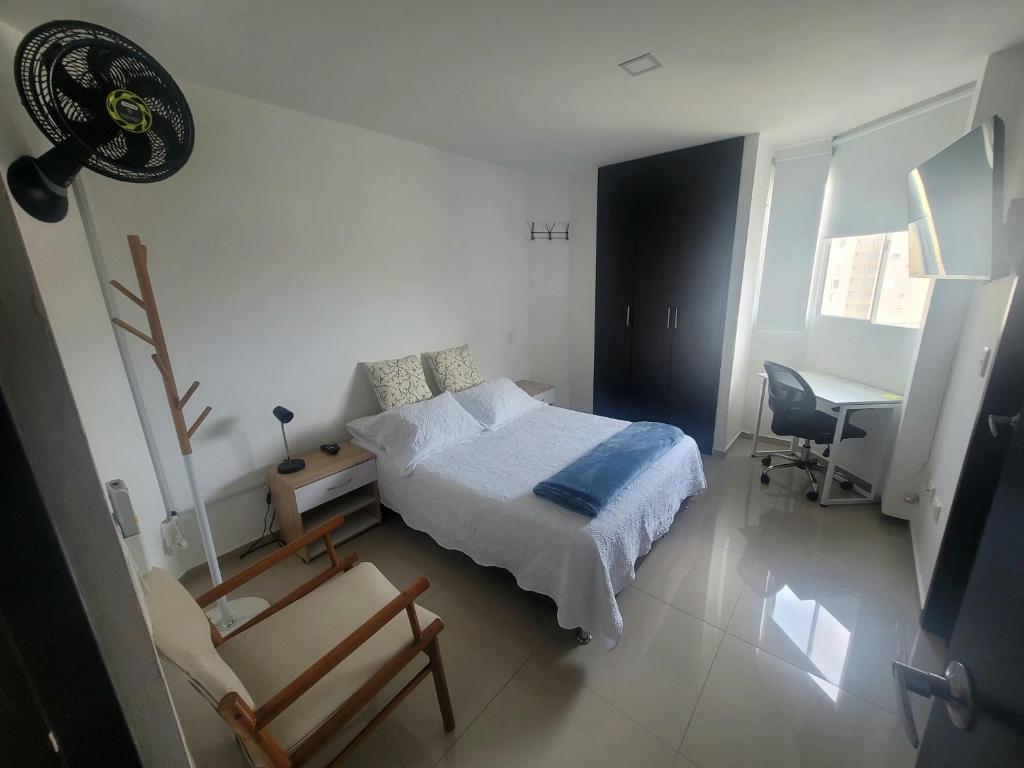 een slaapkamer met een bed, een bureau en een stoel bij Matilda apt - Feel at home in Barranquilla in Barranquilla