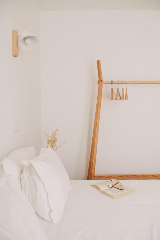 a white bed with a pair of glasses on it at Pure Flor de Esteva in Vila do Bispo