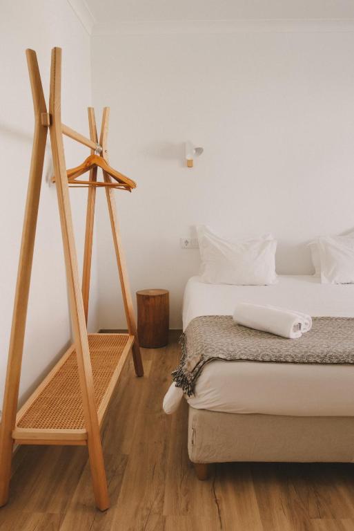 a room with two beds and a wooden tripod at Pure Flor de Esteva in Vila do Bispo