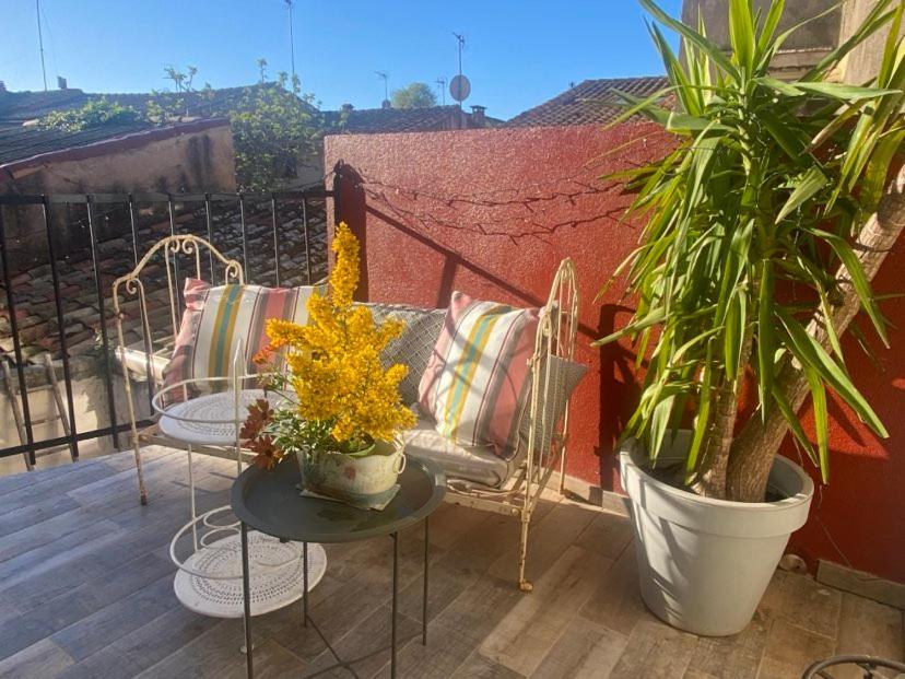 un balcon avec deux chaises et une table avec des plantes dans l'établissement MAISON PLEIN SUD SUR LES TOITS au 2 terrasses, à Montagnac