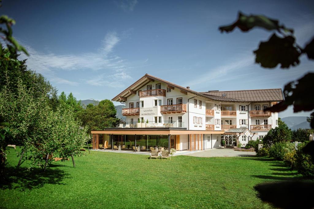 un gran edificio blanco con césped delante en Crystls Aparthotel, en Flachau