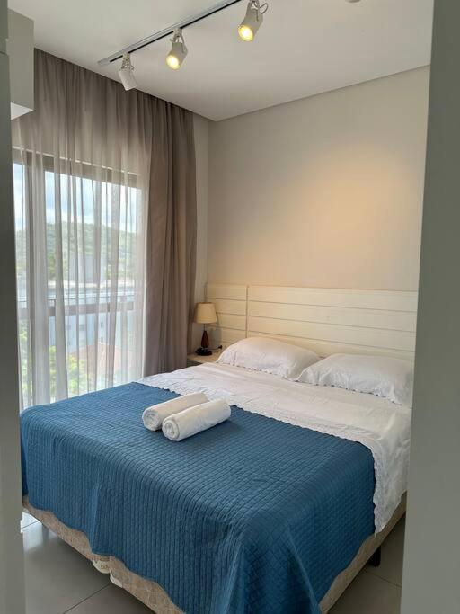 um quarto com uma cama com duas toalhas em Apto 1 suíte, com garagem, Festival 500metros em Joinville