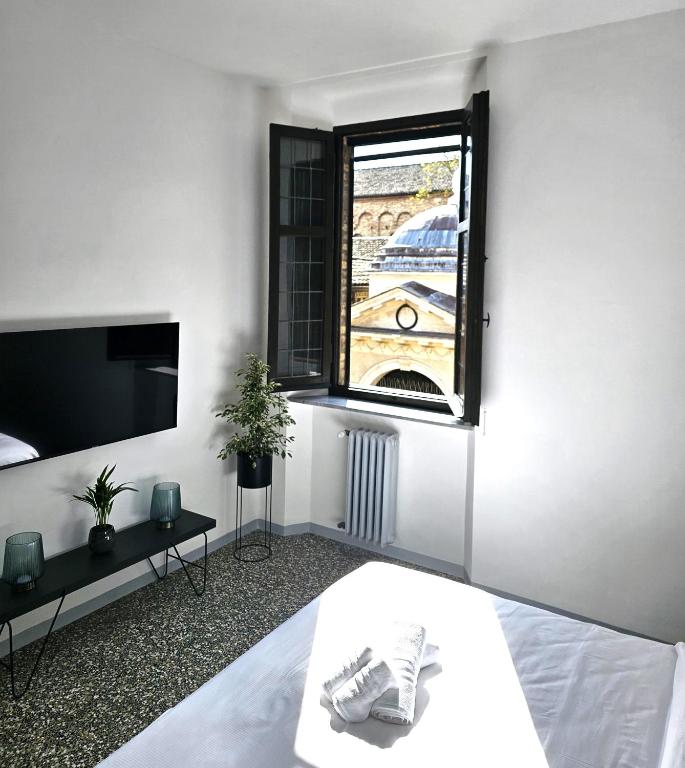 a white room with a bed and a window at Mana Urban Retreat in Ravenna