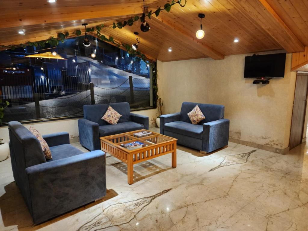 a living room with two chairs and a coffee table at Golden Fern Resort in Shimla