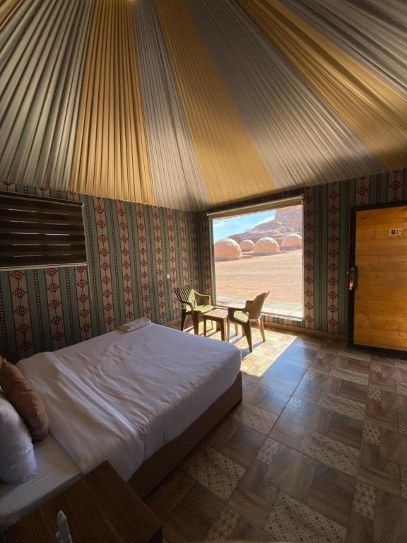 Un dormitorio con una cama y una mesa. en مخيم الانيق, en Wadi Rum