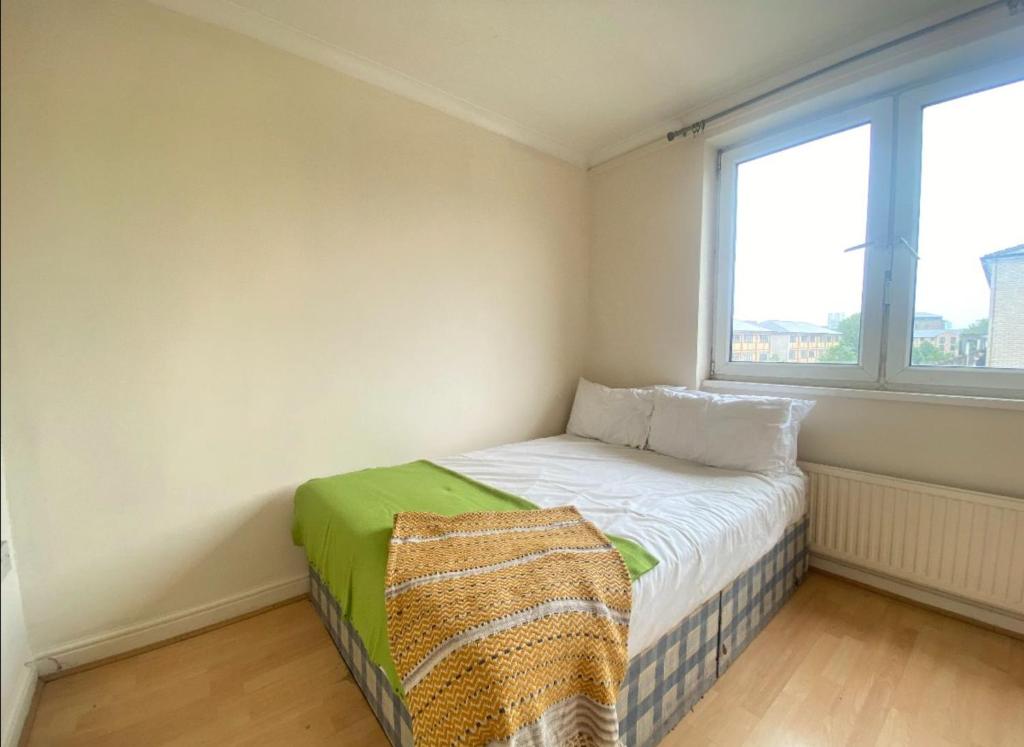 Cama pequeña en habitación con ventana en Modern Room for Rent in Vibrant E14: Your Urban Sanctuary Awaits! en Londres