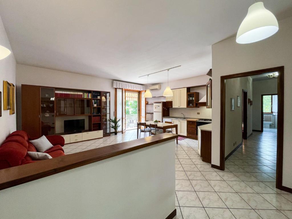 a large kitchen and living room with a red couch at Torre Apartment - Affitti Brevi Italia in Modena