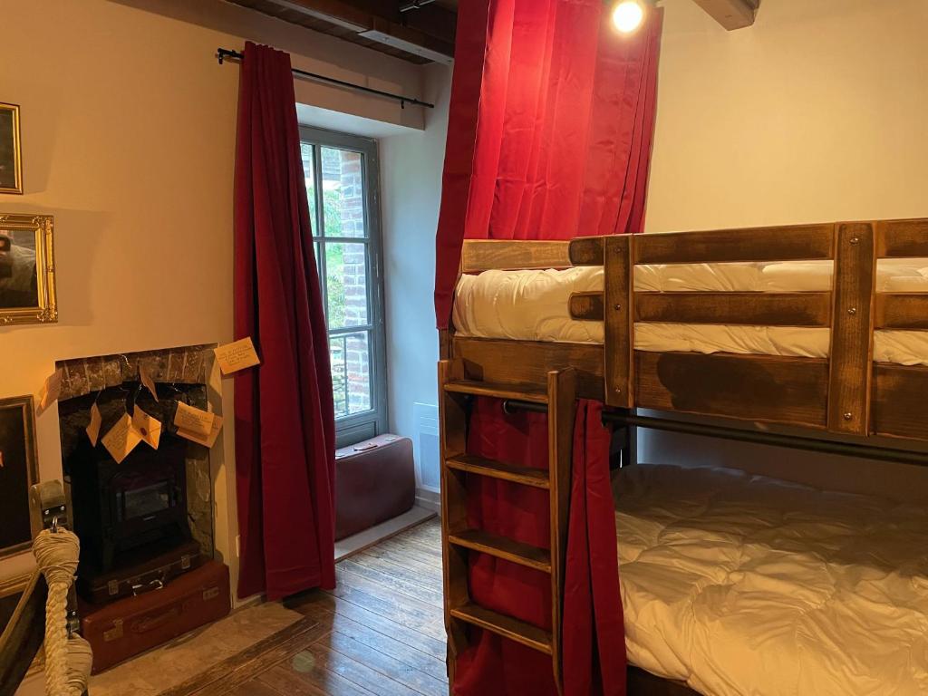 een slaapkamer met 2 stapelbedden en een open haard bij Impasse des Mystères - La maison des Sorciers Léhon/Dinan in Dinan