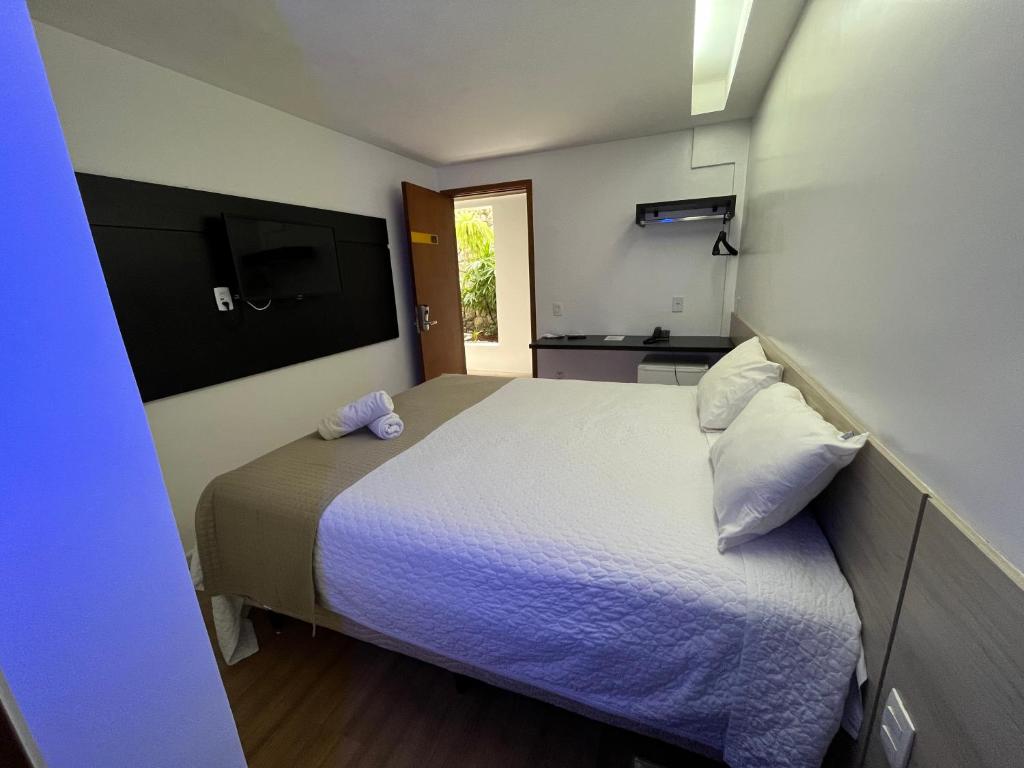 a small bedroom with a bed and a kitchen at Mcz Hotel in Maceió