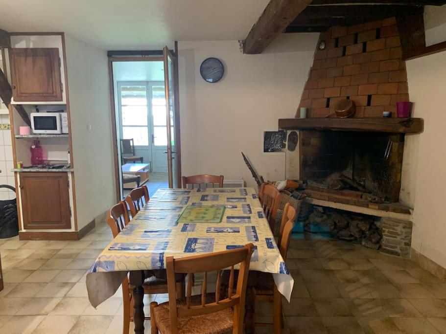 uma sala de jantar com uma mesa e uma lareira em Maison de montagne 8 couchages em Aston