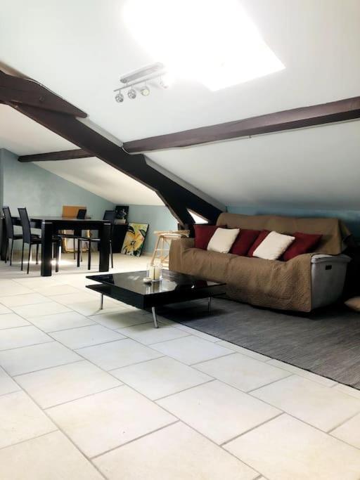 ein Wohnzimmer mit einem Sofa und einem Tisch in der Unterkunft Ambiance Authentique coté gare in Ambérieu-en-Bugey