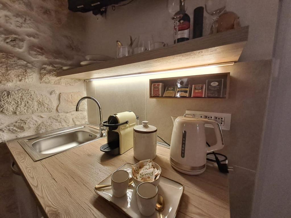 a kitchen counter with a sink and a coffee maker at Eureka luxury room in Ostuni