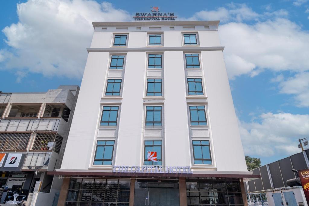 a white building with a sign on top of it at Monday Hotels Swarna's The Capital in Vijayawāda