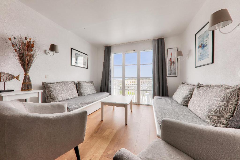 a living room with couches and a large window at Détente et vue sur le port à Arzon in Arzon