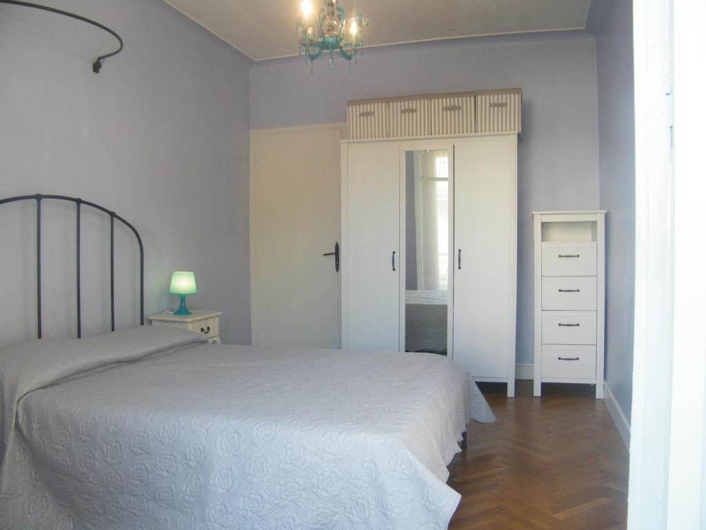 a bedroom with a white bed and a dresser at Apartment 2 chambres Palais HenriIV in Nice