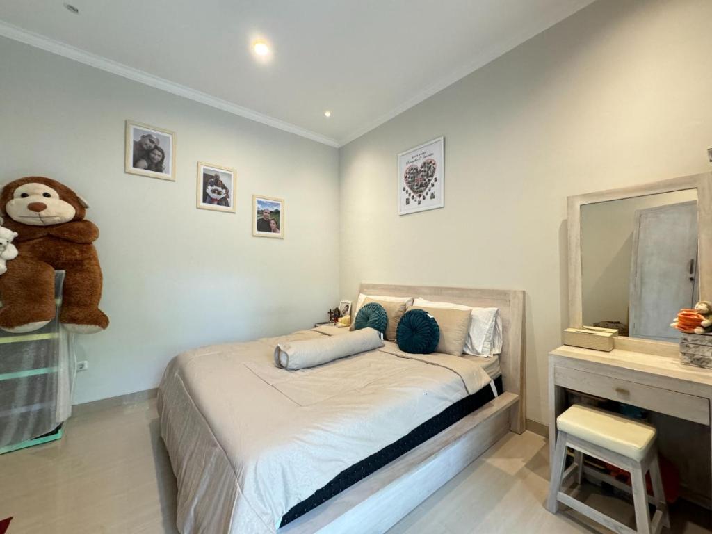 ein Schlafzimmer mit einem Bett mit einem Teddybär drauf in der Unterkunft Villa Kelapa Gading Dalung in Dalung