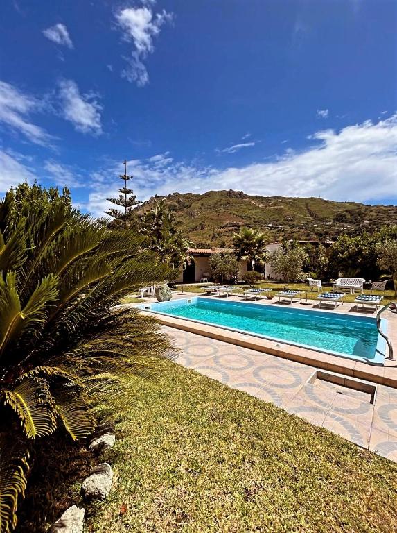 a swimming pool in a resort with a mountain in the background at Case vacanze le Buganville in Ischia