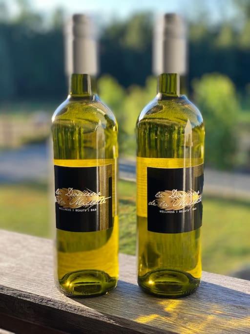 two bottles of wine sitting on top of a wooden table at Familie &amp; Vriendenwoning met fantastisch uitzicht in Ellezelles