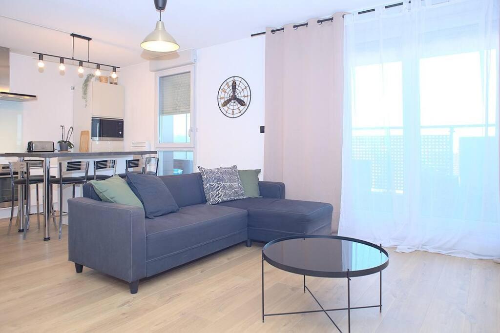 un salon avec un canapé bleu et une table en verre dans l'établissement Cosy Duplex - Ma Cabotte, à Toulouse