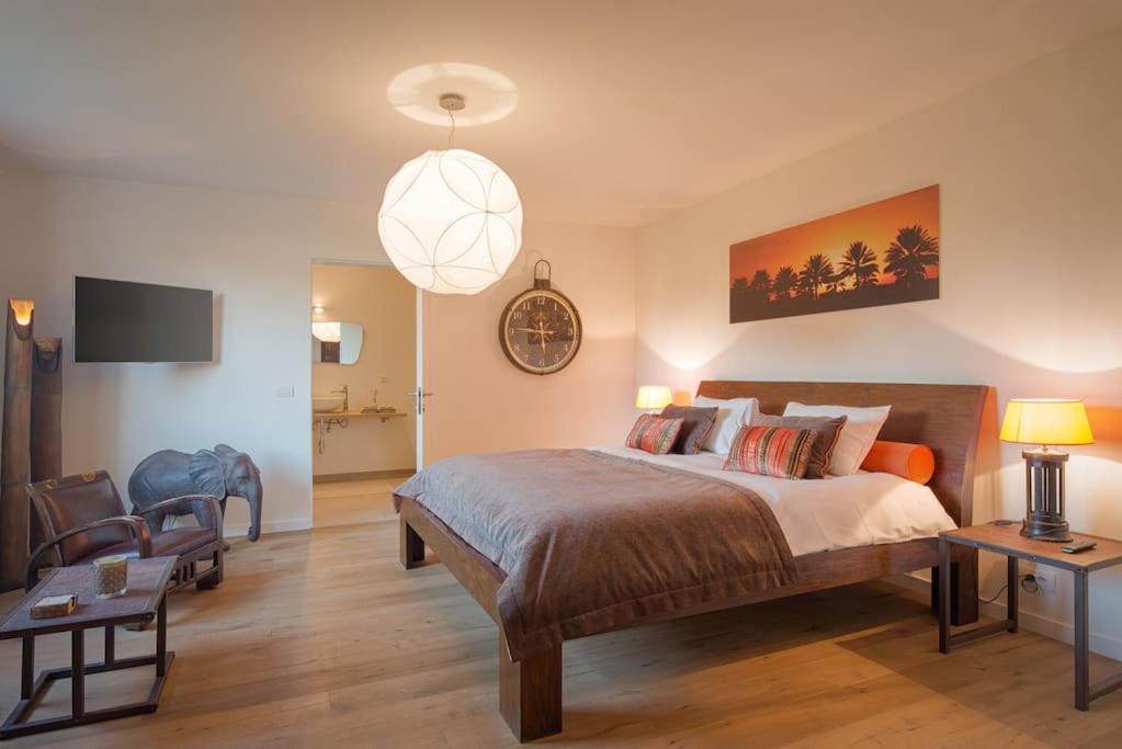 a bedroom with a large bed and a pendant light at Familie &amp; Vriendenwoning met fantastisch uitzicht in Ellezelles