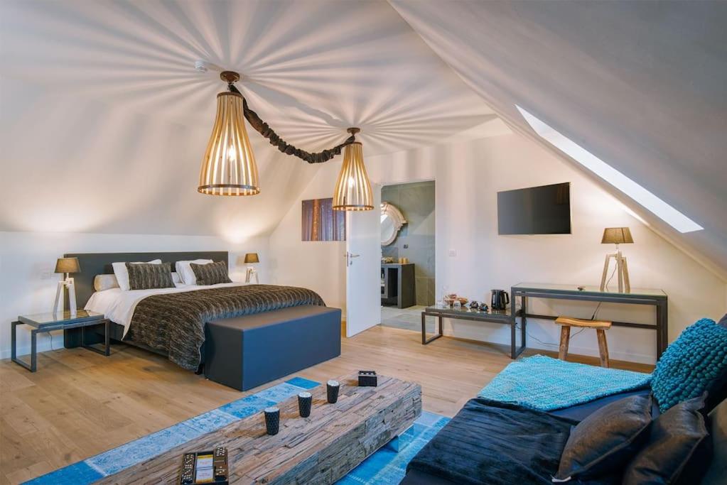 a bedroom with a bed and a living room at Familie &amp; Vriendenwoning met fantastisch uitzicht in Ellezelles