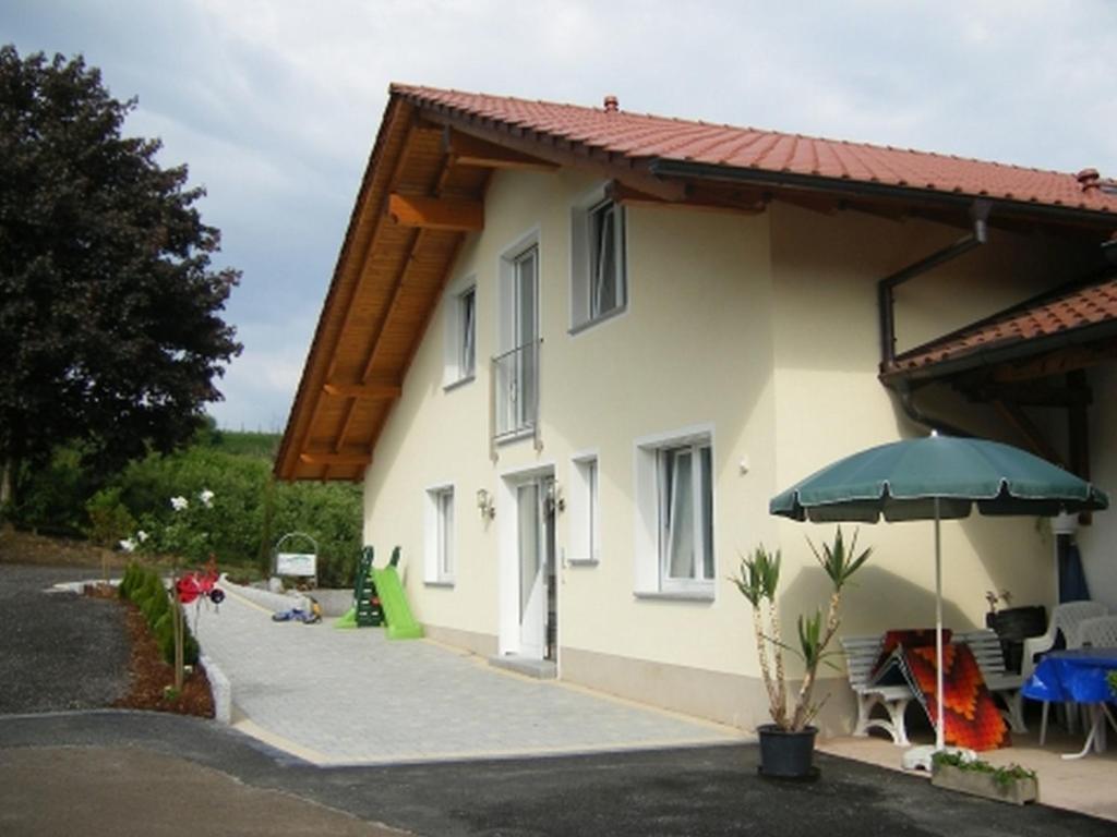 une maison avec un parasol et une terrasse dans l'établissement Weingut Ringwald, à Herbolzheim