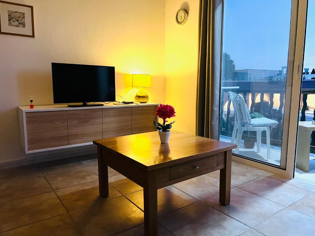 - un salon avec une télévision et une table basse dans l'établissement Cosy Sunny One Bedroom Apartment, à Paphos