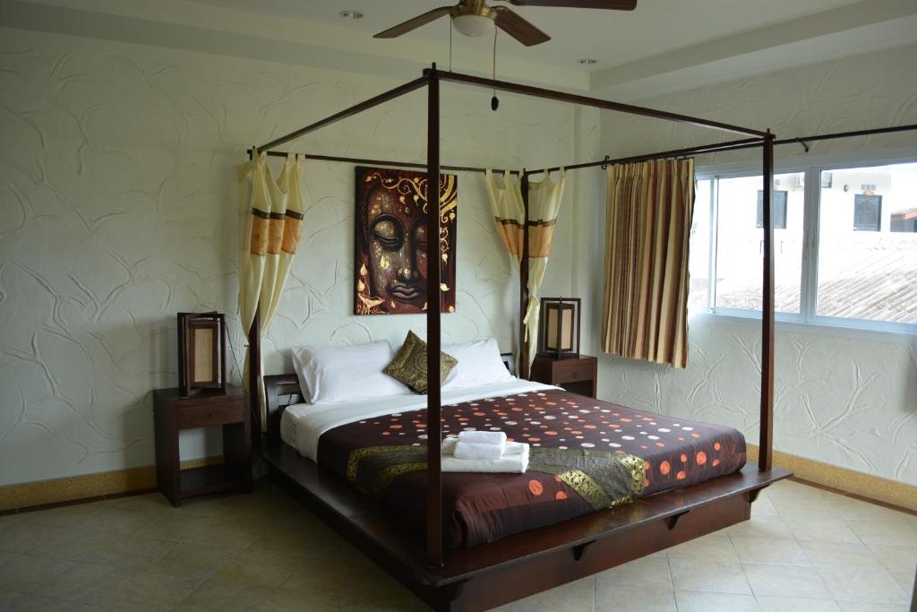 a bedroom with a canopy bed and a window at Nirvana Guesthouse & Hostel in Koh Tao
