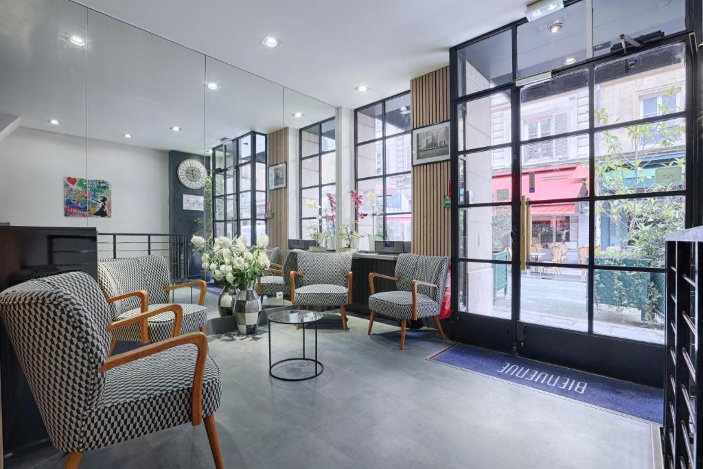 - une salle d'attente avec des chaises, une table et des fenêtres dans l'établissement Hôtel Du Leman, à Paris