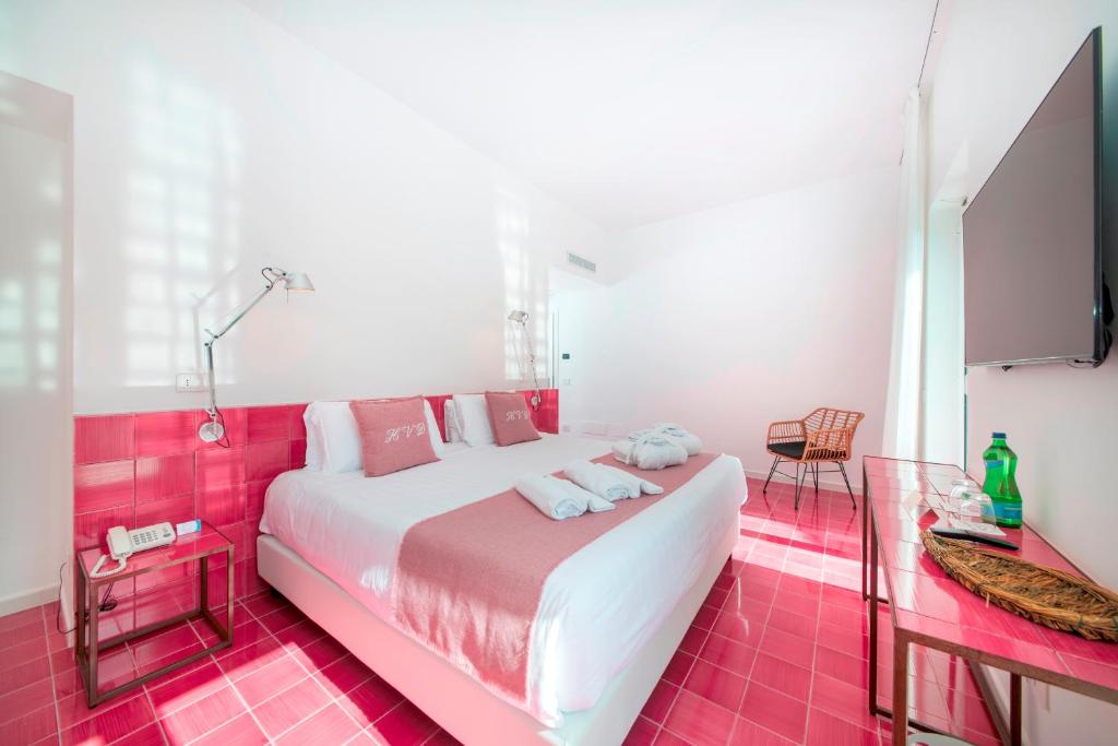 a bedroom with a large white bed with pink tiles at Hotel Villa Durrueli Resort & Spa in Ischia