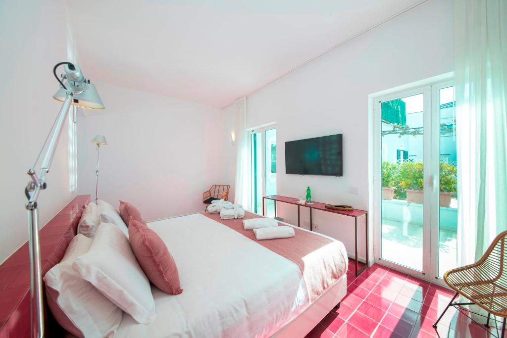 a white bedroom with a bed and a balcony at Hotel Villa Durrueli Resort & Spa in Ischia