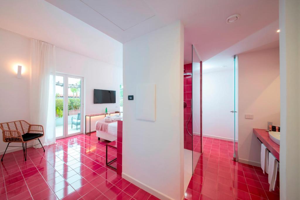 a bathroom with a red tile floor and a bedroom at Hotel Villa Durrueli Resort & Spa in Ischia