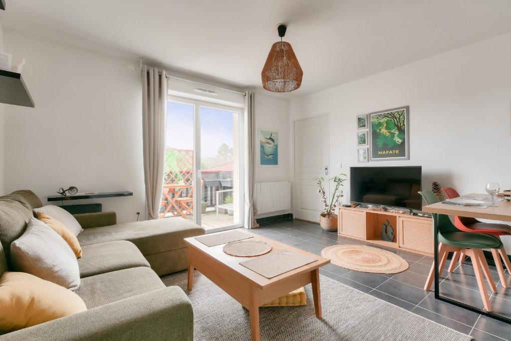un salon avec un canapé et une table dans l'établissement Vacances paisibles à Arès, à Arès
