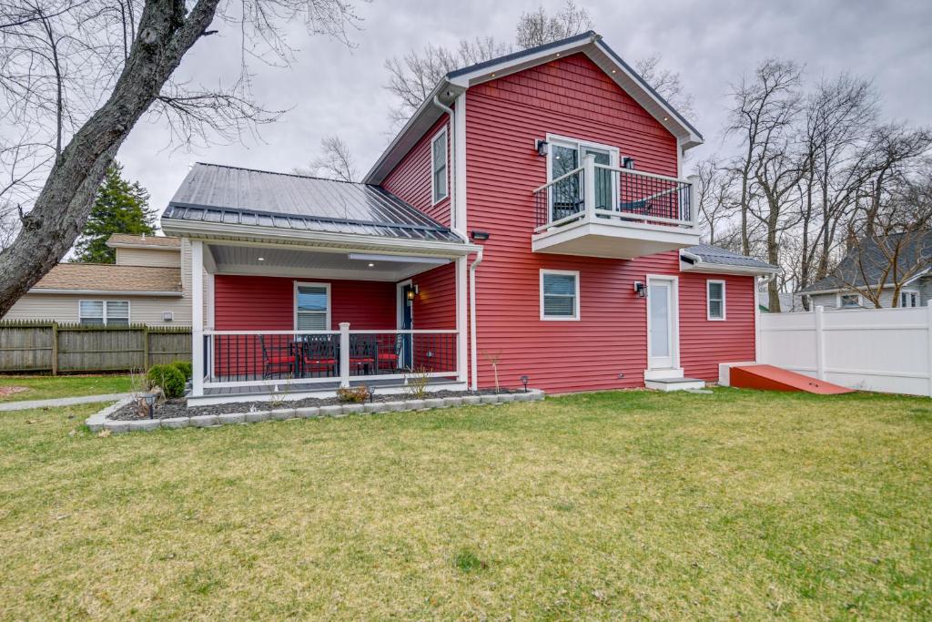 een rood huis met een wit hek in een tuin bij Angola Vacation Rental, Walk to Lake Erie Beach! in Angola-on-the-Lake