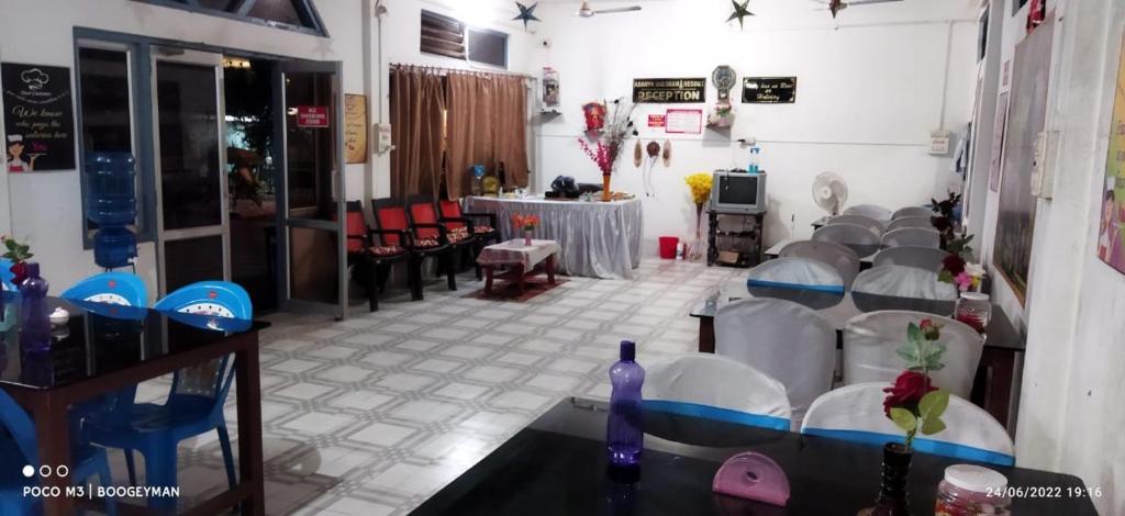 ein Zimmer mit einem Haufen Stühle und einem Tisch in der Unterkunft Aranya Darshan in Lataguri