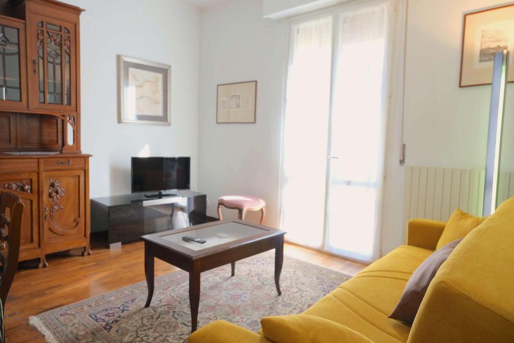 a living room with a yellow couch and a coffee table at Case VR Holiday - Residenza Leo in Verona