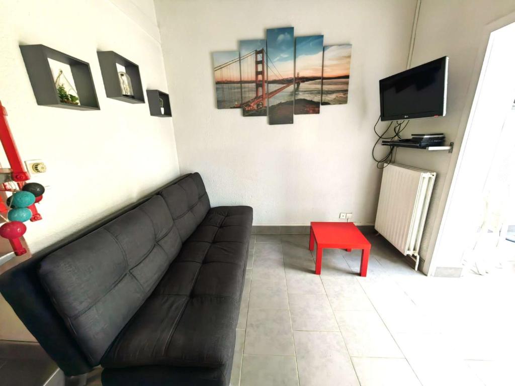 - un salon avec un canapé et un tabouret rouge dans l'établissement Villa Mitoyenne avec Piscine, Parking Privé, à 15 Min de la Plage - FR-1-607-126, au Cap d'Agde