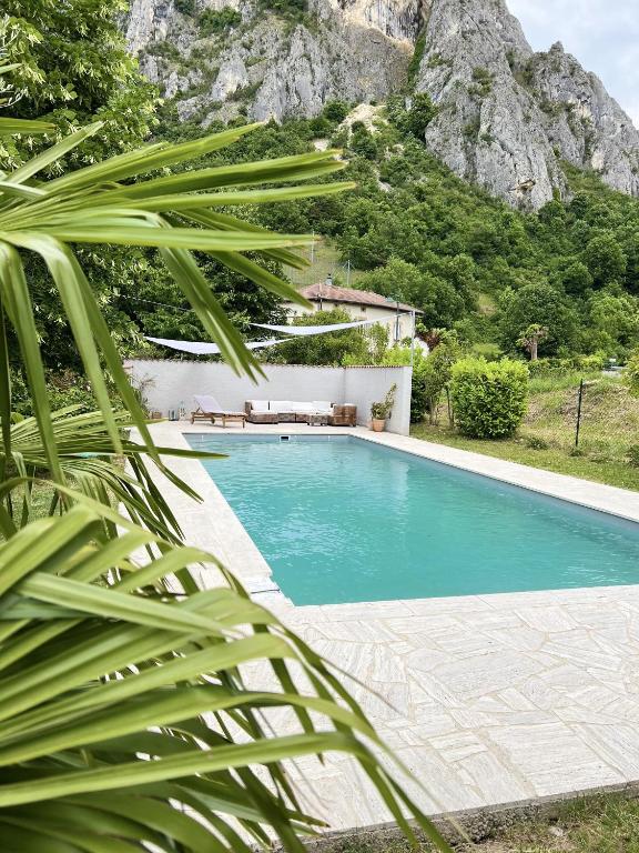 une piscine avec une montagne en arrière-plan dans l'établissement Maison avec vue sur le Vercors, à Beauregard-Baret
