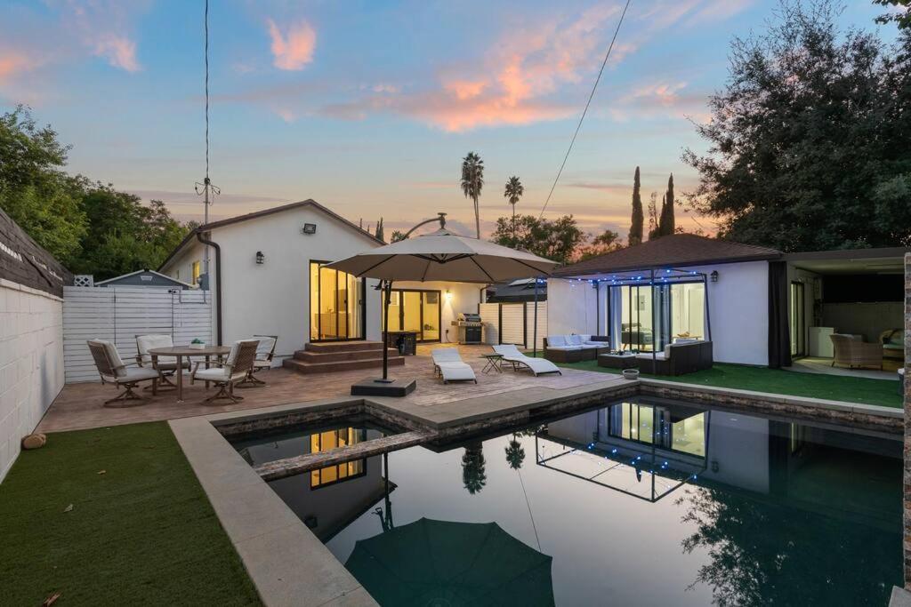 een achtertuin met een zwembad en een huis bij ৎ୭ Luxury Reseda with Pool ৎ୭ in Los Angeles