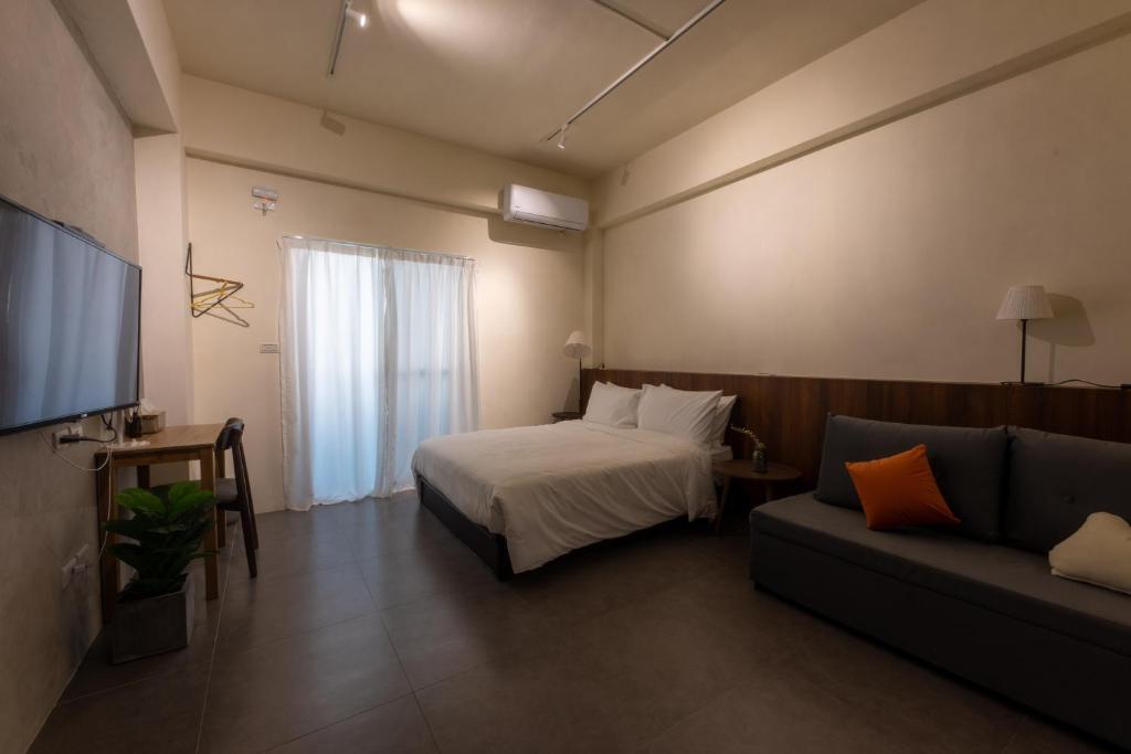 Habitación de hotel con cama y sofá en 木子寓所 Moozhouse, en Magong