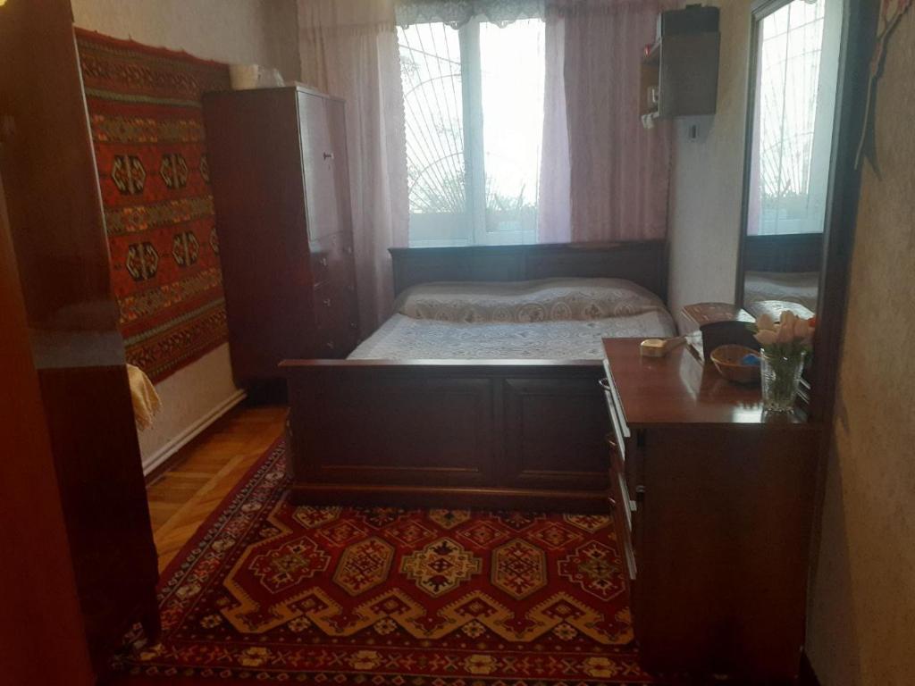 a bedroom with a bed and a dresser and a table at 2-ух комнатная квартира in Baku