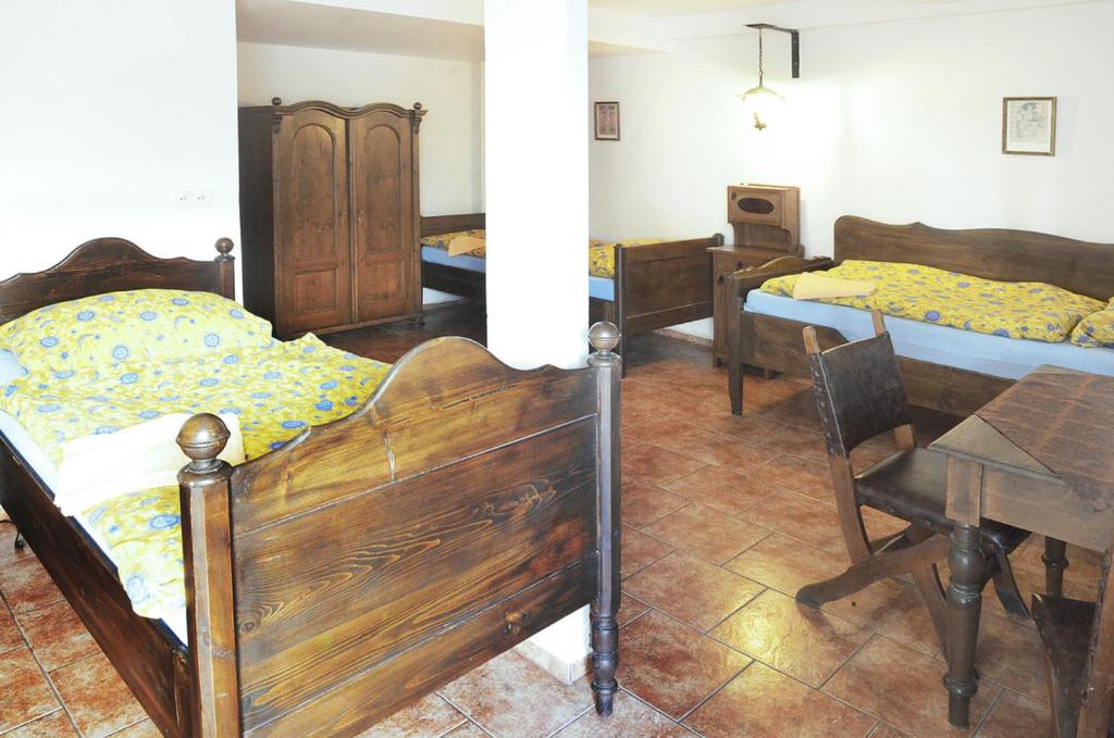 a bedroom with three beds and a table and a desk at Pension Na Staré Poště in Přelouč
