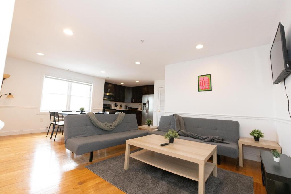 a living room with a couch and a table at Pristine 2-Bed Apt with Skyline Views - mins to NYC in Union City