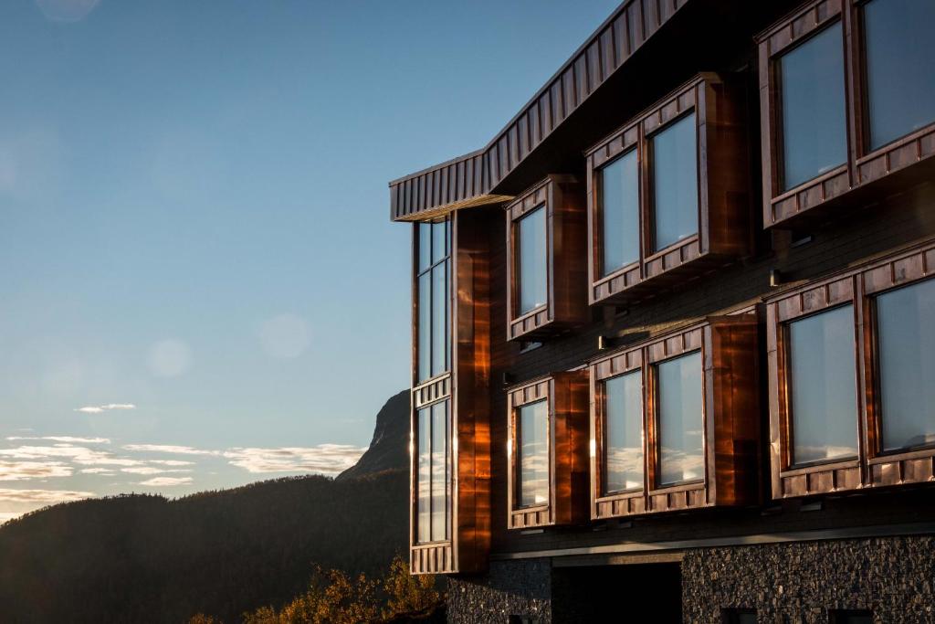 un edificio con finestre e montagne sullo sfondo di Skarsnuten Hotel and Spa by Classic Norway Hotels a Hemsedal