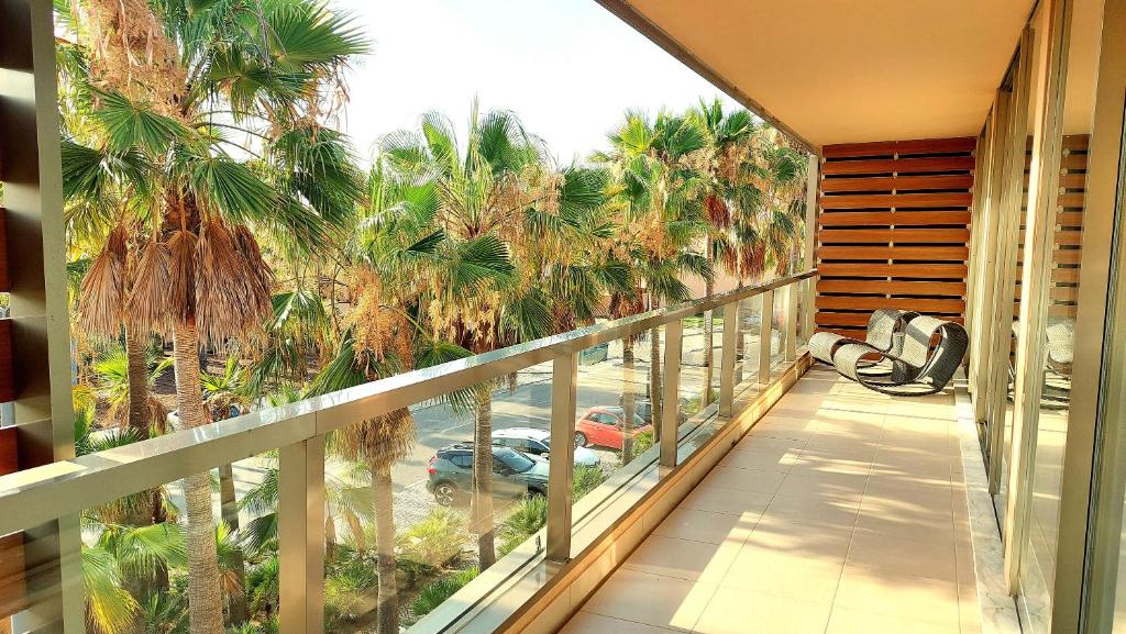 a balcony with a view of a parking lot with palm trees at Herdade dos Salgados - 5b2a in Galé