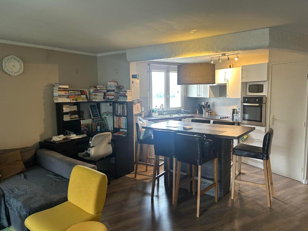 une cuisine avec un canapé et une table avec des chaises dans l'établissement Appartement 3 pièces à Fresnes, à Fresnes