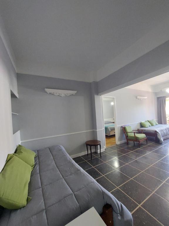 um quarto com uma cama e uma sala de estar em Hotel Lyon by MH em Buenos Aires