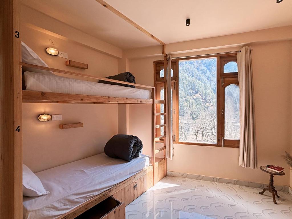 een kamer met 2 stapelbedden en een raam bij Grham Hostel Kasol, Katagla in Kasol