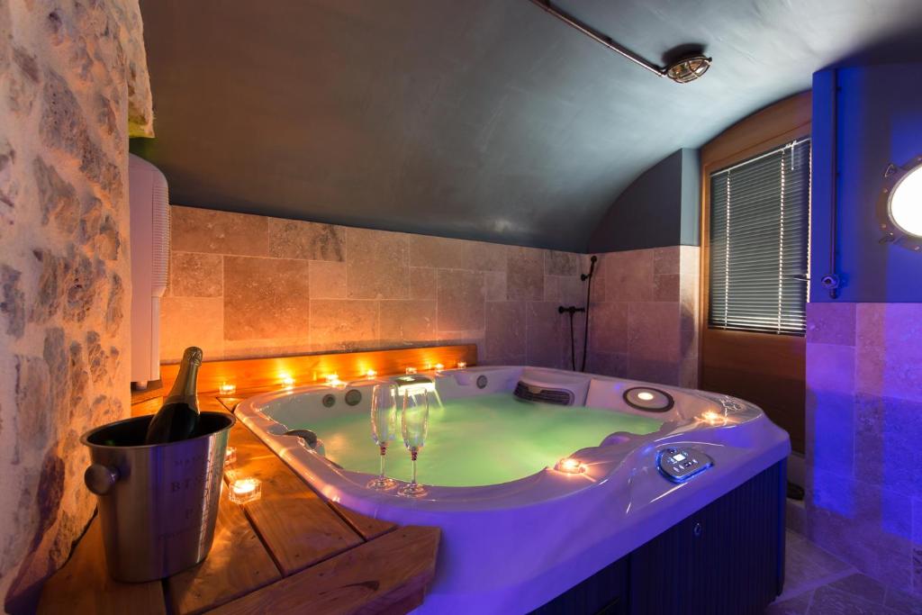 a large bath tub with lights in a bathroom at Logis de Cupidon in Châteauneuf-du-Rhône